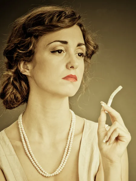 Elinde sigara tutan genç bir kadın.