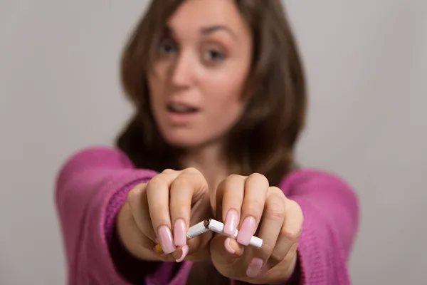 Retrato fuera de foco de una mujer rompiendo un cigarrillo en dos —  Fotos de Stock