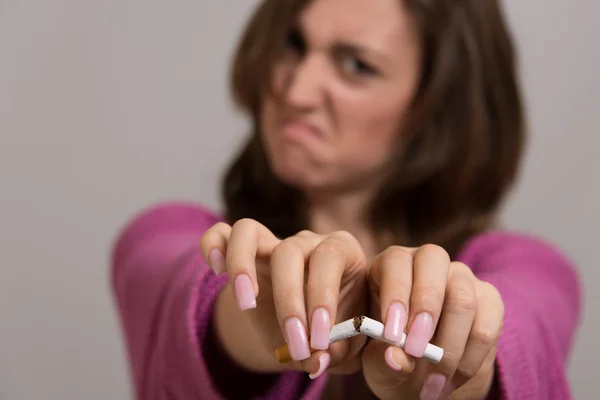 Retrato fuera de foco de una mujer rompiendo un cigarrillo en dos —  Fotos de Stock