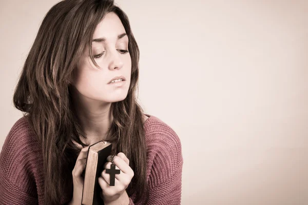 Woman holding a cross intensely, isolated on grey background, READY FOR YOUR TEXT — Stock Photo, Image