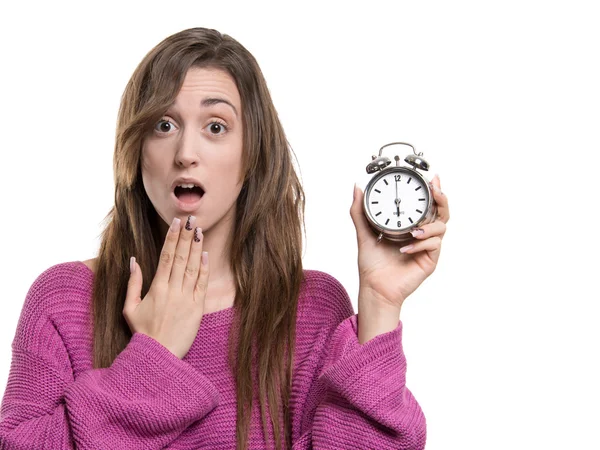 Jovem mulher segurando uma mão na boca, e segurando um relógio às seis horas — Fotografia de Stock