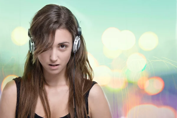 Mujer joven escuchando música desde auriculares, en una imagen horizontal con bokeh artificial —  Fotos de Stock