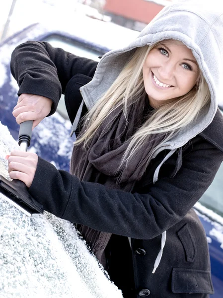 Mujer joven raspando hielo del coche —  Fotos de Stock