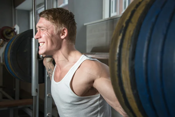 Young man using smith machine — Stock Photo, Image