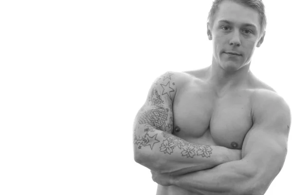 Jonge bodybuilder permanent met armen gekruist, geïsoleerd op witte achtergrond — Stockfoto