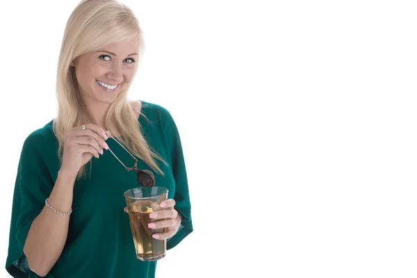 Young smiling woman holding a tall glass of warm drink and a strainer — Stock Photo, Image