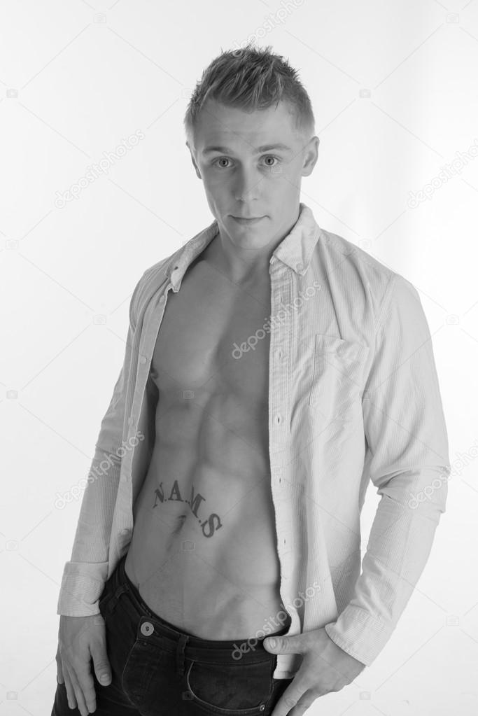 Young muscular man posing in jeans and open shirt