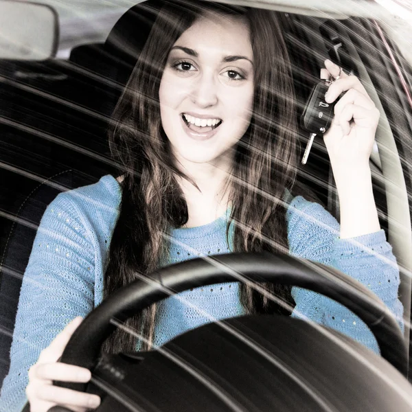 Giovane bruna che tiene chiave auto all'interno della concessionaria auto — Foto Stock