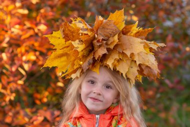 Sonbahar. Sonbahar renklerinde sarı akçaağaç yapraklarından bir çelenk takmış bir kızın portresi.. 