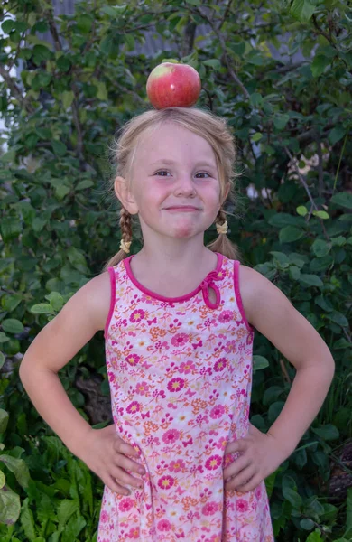 Κορίτσι Έχει Ένα Μεγάλο Ώριμο Ορεκτικό Μήλο Στο Κεφάλι Της — Φωτογραφία Αρχείου