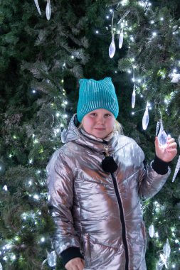 Yılbaşında bir çocuk Noel ağacının yanında duruyor.. 