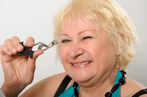 Woman using eyelash curler. — Stock Photo, Image