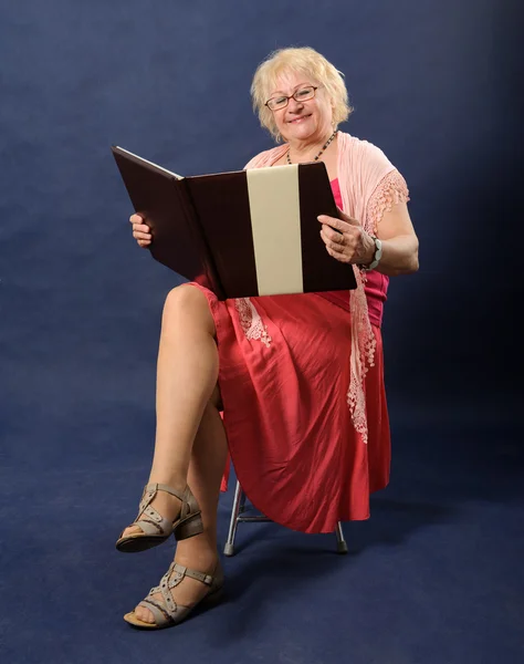 Frau im rosa Kleid liest Buch — Stockfoto