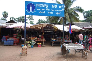 Kamboçyalı ve yabancı gezginler 12 Nisan 2009 'da Siem Reap, Kamboçya' da yerel manav pazarından yiyecek satın almak için seyahat ediyorlar.