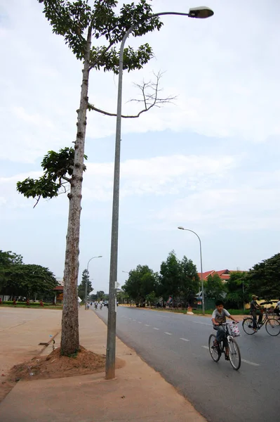 カンボジア人と外国人旅行者2009年4月12日にカンボジアのシェムリアップで交通アンコールワットの道路でバイクや自転車に乗ってシェムリアップの首都で — ストック写真