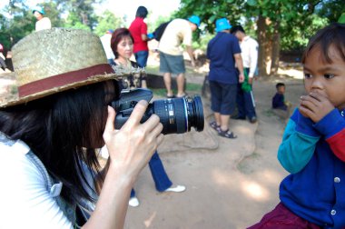 Taylandlı kadın fotoğrafçıların seyahatleri Angkor harabelerini ziyaret eder ve fotoğraf çeker. Kamboçyalı çocuklar 12 Nisan 2009 'da SiemReap' ın başkenti Siem Reap, Kamboçya 'da çocuk resimleri çeker.