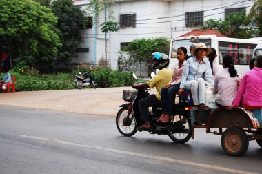 Kamboçyalı insanlar 12 Nisan 2009 'da Siem Reap, Kamboçya' da SiemReap 'in başkentinde trafik Angkor Wat yolunda motosiklet ve bisiklet sürüyorlar.