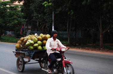 Kamboçyalı insanlar 12 Nisan 2009 'da Siem Reap, Kamboçya' da SiemReap 'in başkentinde trafik Angkor Wat yolunda motosiklet ve bisiklet sürüyorlar.