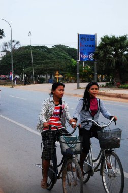 Kamboçyalı insanlar 12 Nisan 2009 'da Siem Reap, Kamboçya' da SiemReap 'in başkentinde trafik Angkor Wat yolunda motosiklet ve bisiklet sürüyorlar.