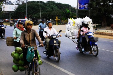 Kamboçyalı insanlar 12 Nisan 2009 'da Siem Reap, Kamboçya' da SiemReap 'in başkentinde trafik Angkor Wat yolunda motosiklet ve bisiklet sürüyorlar.