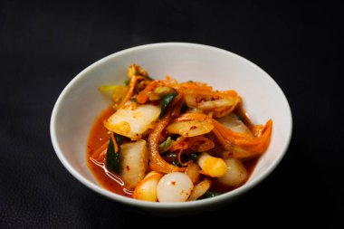 Tayland 'da Bangkok, Tayland' daki restoran kafeteryasında seramik bardakta servis edilen Kore usulü mutfak salatası kimchi veya gimchi yemekleri yapan Taylandlı aşçı.