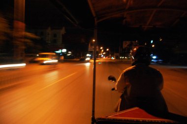 Kamboçya 'daki Kamboçya halkı, Kamboçya' daki Siem Reap, Kamboçya 'da sabah saatlerinde Angkor Wat İmparatorluğu' nun antik harabelerini ziyaret etmek için motosiklet kullanıyor.