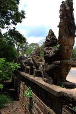 Heykel figürü ilahi melek ruhu ve girişteki Naga heykeli Hindu ve Budist kültüründe Güney Kapısı Köprüsü Nokor Thom 'u inşa eden antik kalıntılar Siem Reap, Kamboçya' daki Angkor Wat 'a gider.