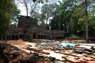Ağaç kökleri ve Antik kalıntılar Prasat Ta Prohm veya Angkor Wat 'ın Antik Brahma Tapınağı Kamboçyalı gezginler için seyahat ziyaretinde Siem Reap, Kamboçya' daki Angkor Thom 'da dua ederek dua ediyorlar.
