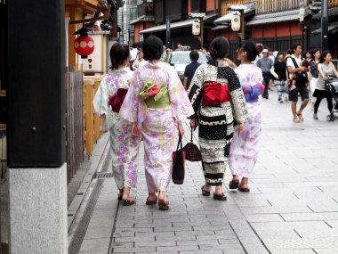 Japon kadın gezginler geleneksel kimono yukata giyerler Hanamikoji Caddesi 'nde yürürler ve 11 Temmuz 2015' te Japonya 'nın Kansai şehrinde Gion' un eski kasabasında alışveriş yaparlar.