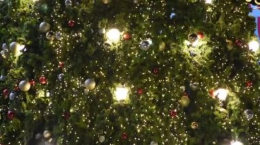 Tayland 'da Tayland' a gidip fotoğraf çeken müşteriler için alışveriş merkezinin bahçesindeki açık teras bahçesinde bulunan yılbaşı ağacının üzerinde bulunan renkli ışık ve lamba Bokeh hareketliliği