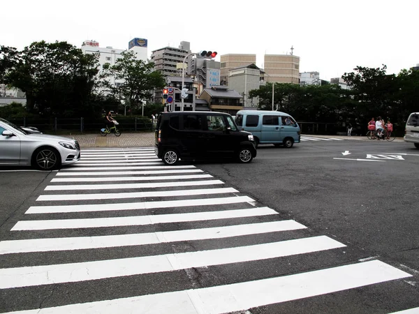 2015年7月11日 京都市内の雑木林を自転車で横断する日本人と祇園旧市街の花見小路通りで交通量の多い街並みを眺めよう — ストック写真