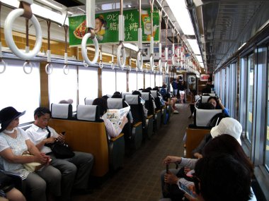 İç dizayn yerel tren ve Japon ve yabancı yolcular, 11 Temmuz 2015 'te Japonya' nın Kansai şehrinde Arashiyama istasyonunda hizmet yolculuğunu ve tren yolculuğunu kullandılar.