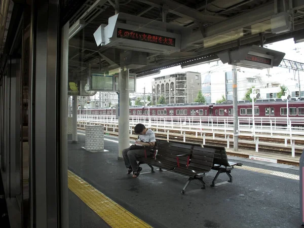 2015年7月11日京都旧市街の西京都市の嵐山駅のターミナルで日本人と外国人旅行者が待機中のサービス旅の鉄道 — ストック写真