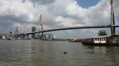 Tayland halkı 26 Aralık 2021 'de Samut Prakan, Tayland' da Chao Phraya veya Chaopraya nehrinde Samutprakarn 'daki Bhumibol Köprüsü' nde gemi ve römorkör kargo taşımacılığı yapıyor.