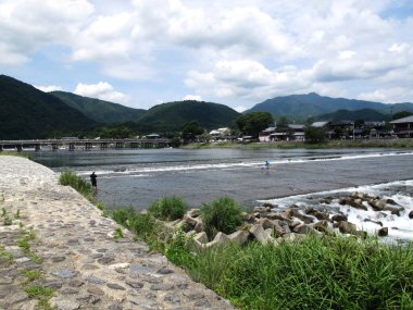 Japon baba ve oğlu, Japonya 'nın Kansai kentindeki Kyoto şehrinde, ulusal olarak belirlenmiş tarihi yer ve manzaralı bir yer olan Arashiyama Nehri' nde su balığı avlamak için seyahat ediyor.