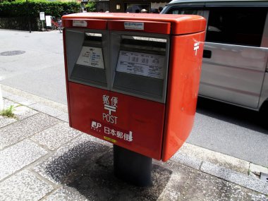 Classic antique vintage retro red public post box on street path for japanese people use send receive mail at outdoor beside road at Arashiyama old town at Kyoto city on July 11, 2015 in Kansai, Japan