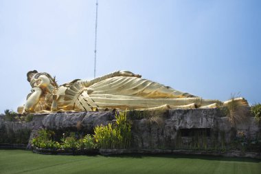 Tayland 'ın Nakhon Pathom kentindeki Sam Phran şehrindeki Wat Tham Panyaram Bangmuang tapınağına gidip dua eden Taylandlı ve Taylandlı gezginler için yaslanmış Guanyin veya Quan Yin uyku heykeli.