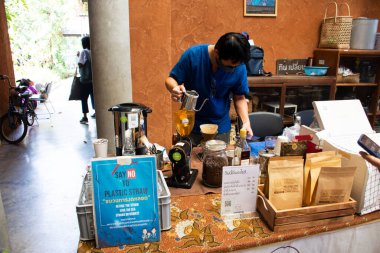 Taylandlı barmenler 15 Ocak 2022 'de Bangkok, Tayland' da sokak organik çiftçi pazarı festivalinde kahve dükkanında damlatan kahve makinesi ya da damlatan sıcak ve buzlu kahve kullanıyorlar.