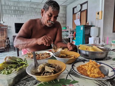 Taylandlı ihtiyarlar yerel yemek yiyorlar güney tarzı öğle yemeklerini Phatalung 'daki kırsal evde öğle yemeği için masaya koyuyorlar 18 Kasım 2020' de Phatthalung, Tayland 'da