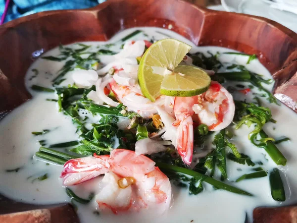 Traditional local thai southern food Coconut milk with shrimp and Gnetum gnemon or baegu vegetables soup for served guest customer on table at restaurant cafe shop in Bangkok, Thailand