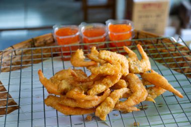 Taylandlılar, Tayland 'ın Pathumthani şehrinde, Ing Nam Sam Khok' ta seyyahlar için hamur kızartması, karides ve tatlı ekşi sos pişiriyor.