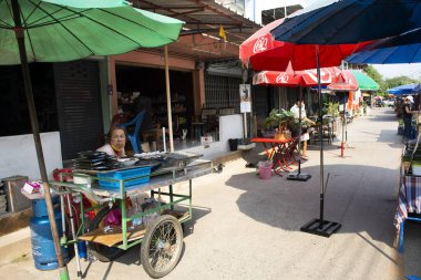 Taylandlı ve yabancı gezginler, 5 Mart 2022 'de Pathumthani şehrindeki Ing Nam Sam Khok sokak pazarında alışveriş yapan yiyecek içecek ürünlerini ziyaret ediyor.