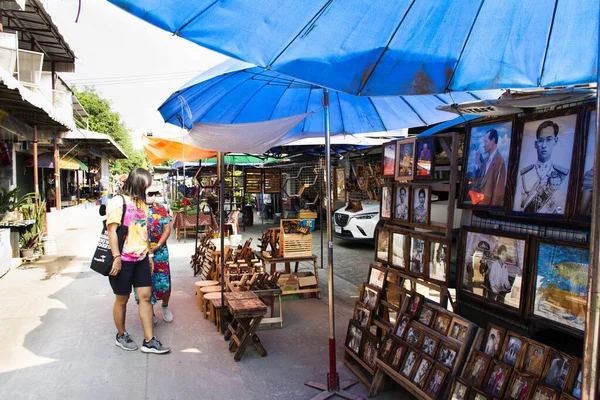 Taylandlı ve yabancı gezginler, 5 Mart 2022 'de Pathumthani şehrindeki Ing Nam Sam Khok sokak pazarında alışveriş yapan yiyecek içecek ürünlerini ziyaret ediyor.