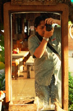 Taylandlı fotoğrafçılar seyahat eder ve dijital fotoğraf çekimi kullanır. Tayland 'ın Sukhothai kentindeki Si Satchanalai' de yerel restoran kafe dükkanında ayna camı ile selfie çekerler.