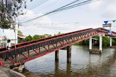 Bangyai şehrindeki Khlong Om Non Kanalı 'ndan geçen antika antika kırmızı köprü inşaatı Tayland' ın başkenti Bangkok 'ta 11 Mayıs 2017' de Wat Tanod Tapınağı yüzer pazarına seyahat edenler için yapıldı.