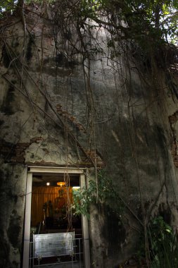 Antik Buda heykeli eski harabelerde terk edilmiş Tayland tapınağının yukarısında 15 Mart 2022 'de Nonthaburi, Tayland' da bulunan Bang Kruai 'de, Wat Sak Noi' de kutsal ibadete saygıyla gidin.