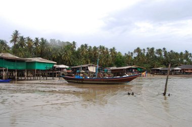 Tahta uzun kuyruk teknesi yollamak için Taylandlı gezginler Ko Phithak Adası 'nı ziyaret edip gece vakti Chumphon, Tayland' daki Koh Pitak balıkçı köyünde balık yakalamak için bekliyorlar.