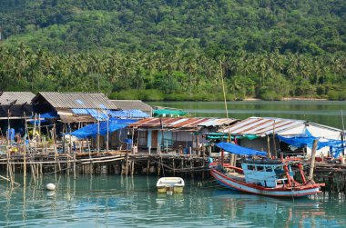 Denizde yüzen deniz manzarası ve balıkçı teknesi Trat, Tayland 'da Tayland Körfezi' ndeki Koh Chang adasındaki balıkçı köyü evinde balık ve deniz yaşamı yakalamak için bekliyor.