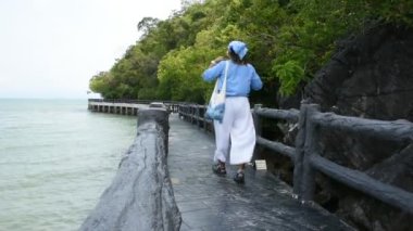 Tayland 'ın başkenti Satun' da bulunan La Ngu şehrindeki Pak Bara balıkçı köyündeki Mu Ko Petra Ulusal Parkı 'ndaki deniz okyanusu taştan köprüsünde seyahat eden gezginler seyahat eder ve yürürler.