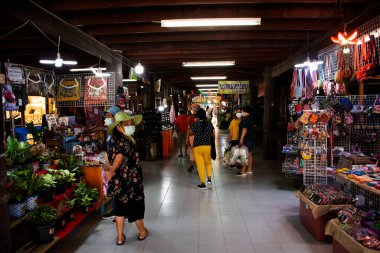 Taylandlı yabancılar 9 Nisan 2022 'de Tayland Nakhon Pathom, Tayland' da Talad Nam Lumphaya Tapınağı veya Wat Lam Phaya Yüzen Pazarı 'ndaki bakkal ahşap teknesinden alışveriş yaparak geziyorlar.